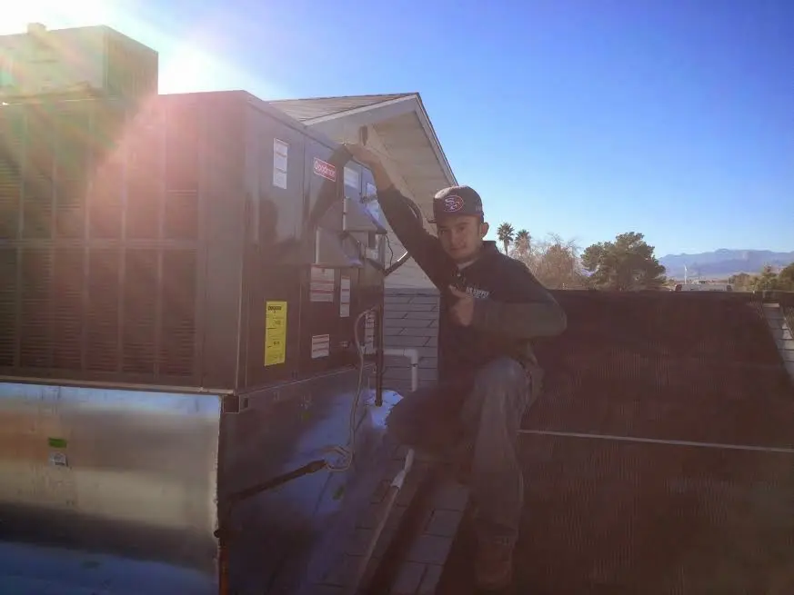 HVAC technician performing Air Duct Repair on a rooftop unit in Sugarland Run